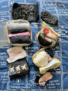 an open suitcase sitting on top of a bed covered in clothing and other items,