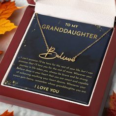 a necklace with the words to my granddaughter on it in a gift box next to autumn leaves