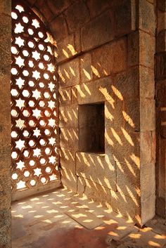 the sun is shining through some windows in an old stone building with lattices on it