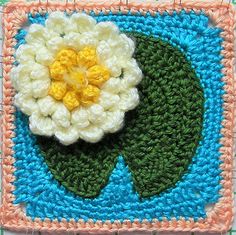 a crocheted square with a flower on it