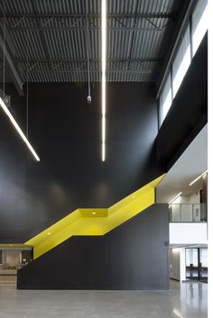 an empty room with black walls and yellow stairs