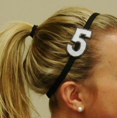 a woman wearing a black and white number 5 headband with her hair in a ponytail