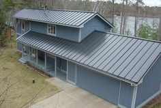 an aerial view of a house with a metal roof and blue siding on the front