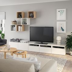 a living room filled with furniture and a flat screen tv on top of a white entertainment center