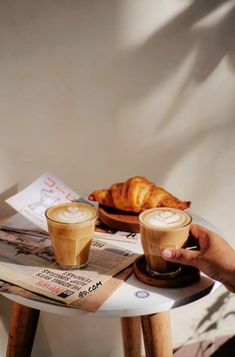 two cups of coffee sitting on top of a table