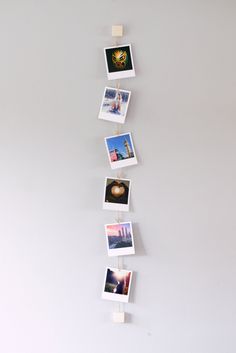 a white wall with pictures hanging from it's sides and some magnets attached to them