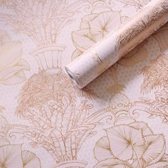 a roll of toilet paper sitting on top of a floral wallpaper