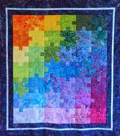 a multicolored quilt hanging on the wall