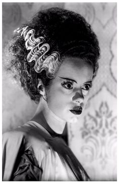 a black and white photo of a woman with curly hair in a bun hairstyle