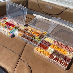 two plastic containers filled with different types of food on top of a brown leather couch