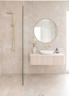 a bathroom with a sink, mirror and shower head in it's center wall