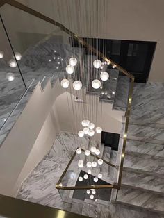 an elegant staircase with chandelier and marble flooring in a modern house or apartment