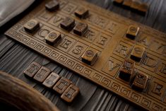 an old wooden typewriter with letters and numbers carved into it's sides, sitting on a table