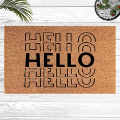 a door mat with the words hello hello on it next to a potted plant