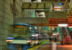 a train traveling through a subway station next to stairs