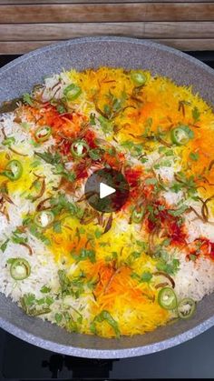 a pan filled with rice and vegetables on top of a stove