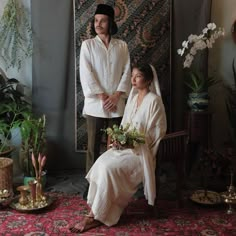 a man and woman dressed in white sitting next to each other