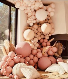 a bunch of balloons that are on the ground in front of a fire place and window