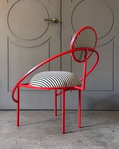 a red chair with a black and white striped seat