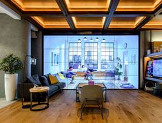 a living room filled with furniture and a flat screen tv sitting on top of a wooden floor