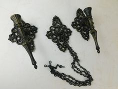 three antique style wall sconces with chains attached to them on a white surface