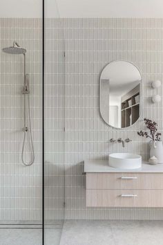 a bathroom with a sink, mirror and shower stall in it's center area