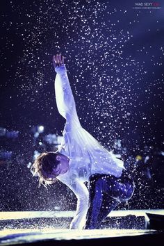 a man in white shirt and blue pants doing a handstand on the ground