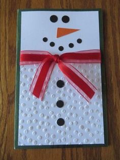 a white card with a red ribbon and a snowman's head on it