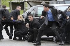 a group of people in suits and ties are trying to get out of a car