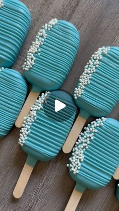 six blue and white lollipops sitting on top of a wooden table next to each other