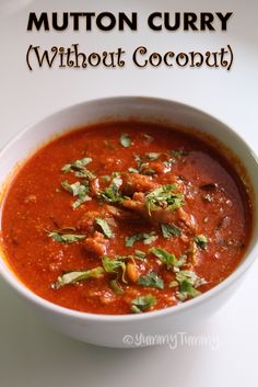 a white bowl filled with red sauce and garnished with cilantro leaves