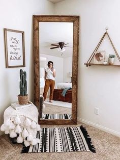 a woman is taking a selfie in the mirror while she stands by her bed