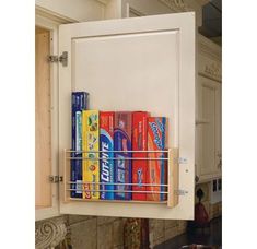 the kitchen cabinet door is open and has several cans on it, as well as a pull out spice rack