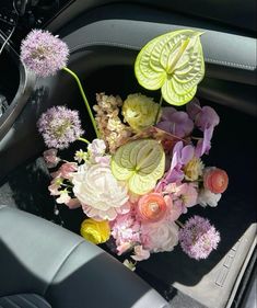 a bouquet of flowers sitting in the center console of a car