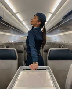 a woman in an airplane with her hand on the seat and looking at something behind her