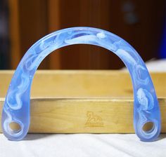 a blue plastic object sitting on top of a wooden table next to a white cloth