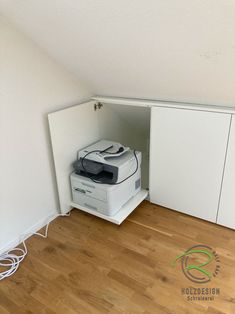 a printer sitting on top of a white cabinet in a room with hard wood floors