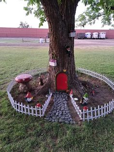 a tree with a red door in the middle of it and some rocks around it