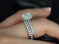 a close up of a person's hand with a diamond ring