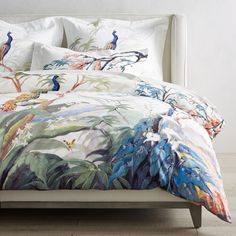 the comforter is made up with colorful birds on it