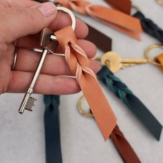 a hand holding a key chain with several different colored keys attached to it and tied together