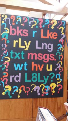 a large black sign with colorful letters and question marks on it's back wall