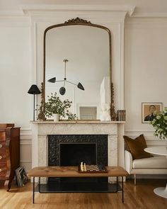 a living room filled with furniture and a large mirror on the wall above a fireplace