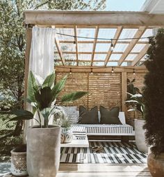 an outdoor living area with potted plants and couches