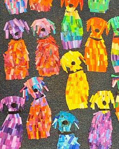 many different colored paper dogs are on the ground with their faces cut out and pinned together