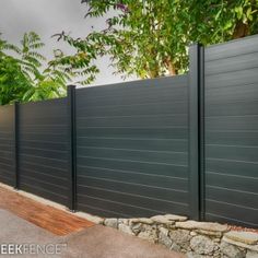 a black fence is next to a stone wall