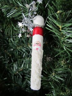 an ornament hanging from a christmas tree with a santa clause face on it