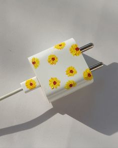 two white and yellow flowers are attached to an electrical outlet on a wall or ceiling