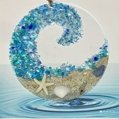 an ornament made out of sea glass and seashells in the water