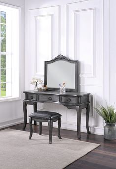 a black vanity with mirror and stool in front of a window on a carpeted floor